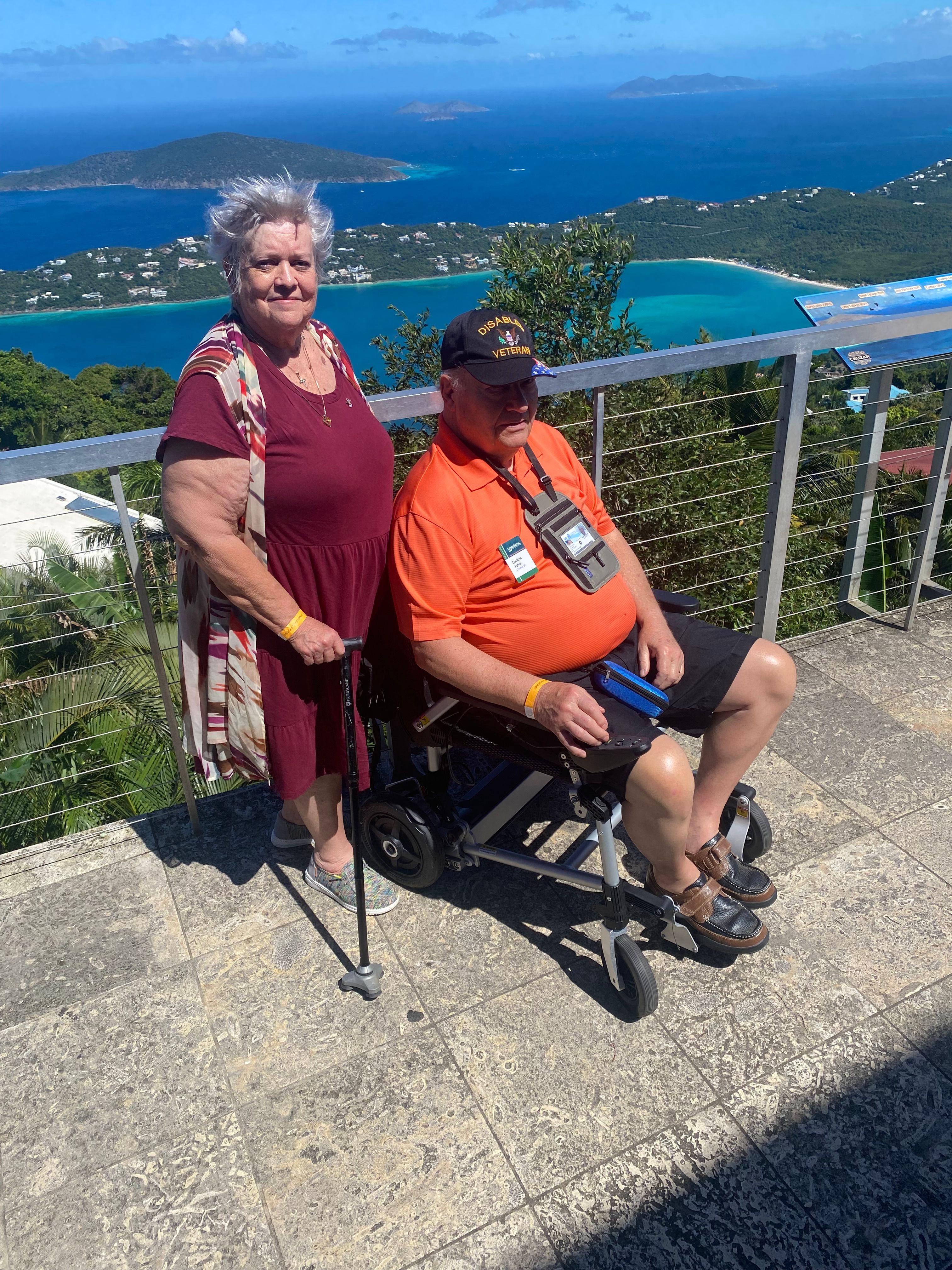 Couple in front of sea view with power chair