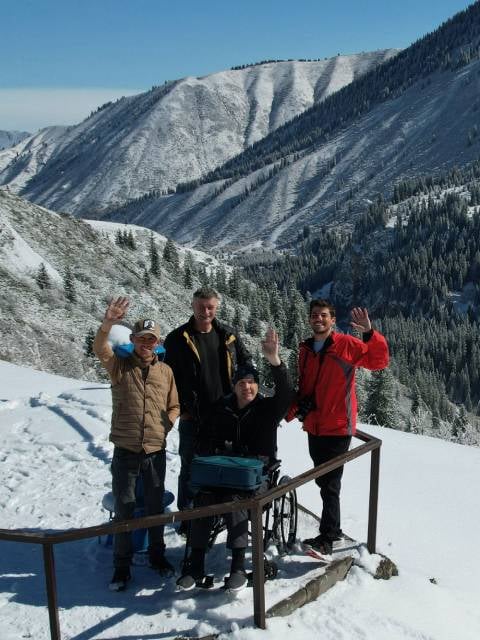 Family near snowy mountain with power chair